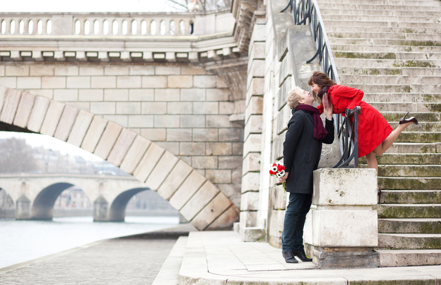 Beautiful romantic couple kissing on a Parisian embankment at sp