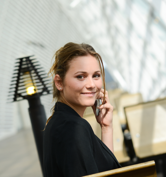 isolated portrait of cheerful young business woman in a public station